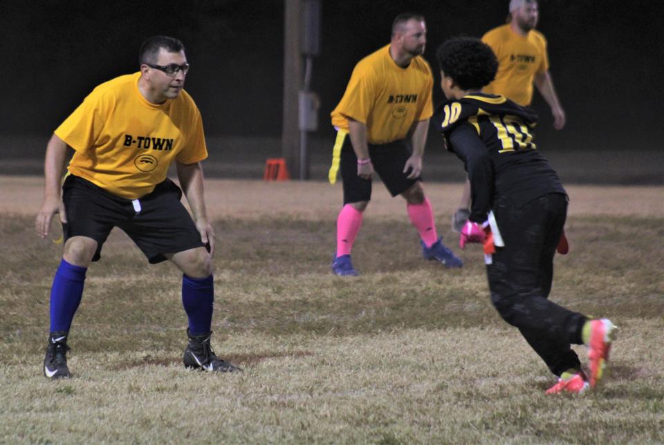 Bellevue city police chief Jon McClain plays defense as Bellevue's varsity football team played a flag football game Friday against members of the Bellevue police department and other adult members of the community.