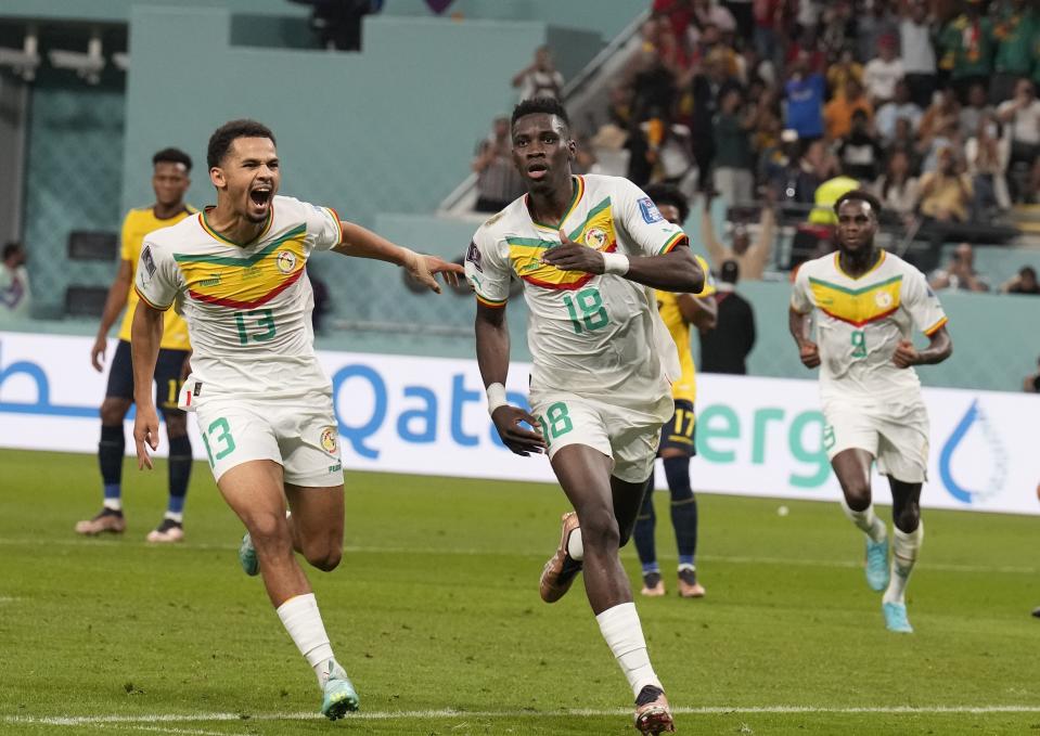 Senegal's Ismaila Sarr, right, celebrates with teammates after scoring a penalty, the opening goal of his team, during the World Cup group A soccer match between Ecuador and Senegal, at the Khalifa International Stadium in Doha, Qatar, Tuesday, Nov. 29, 2022. (AP Photo/Natacha Pisarenko)