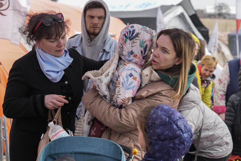 Refugees wait in a line after fleeing the war from neighboring Ukraine at the border crossing in Medyka, southeastern Poland, Sunday, April 10, 2022. (AP Photo/Sergei Grits)
