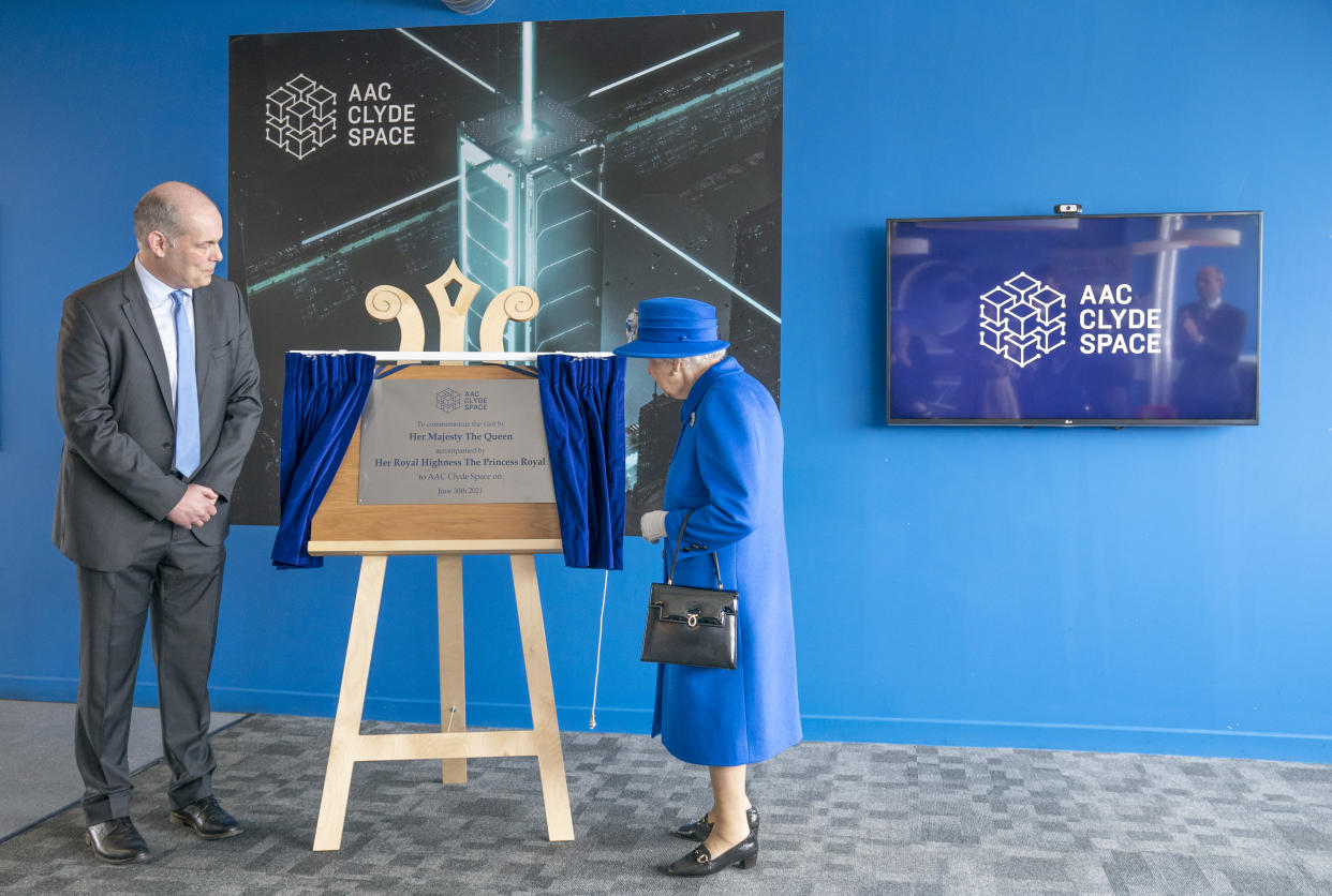 Queen Elizabeth II, who was accompanied by The Princess Royal, unveils a plaque in the offices of AAC Clyde Space during a visit to Skypark, Glasgow, to receive a briefing from the UK Space Agency and view satellite production, as part of her traditional trip to Scotland for Holyrood Week. Picture date: Wednesday June 30, 2021.