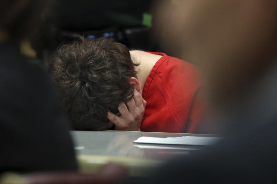 School shooting suspect Nikolas Cruz plugs his ears and ducks his head as two videos of him predicting the Stoneman Douglas High School massacre are played during a hearing at the Broward Courthouse in Fort Lauderdale, Fla., Tuesday, May 28, 2019. Cruz, who faces the death penalty if convicted, is accused of killing 17 and wounding 17 in the February 2018 mass shooting at Marjory Stoneman Douglas High School in Parkland, Fla. (Amy Beth Bennett/South Florida Sun Sentinel via AP, Pool)