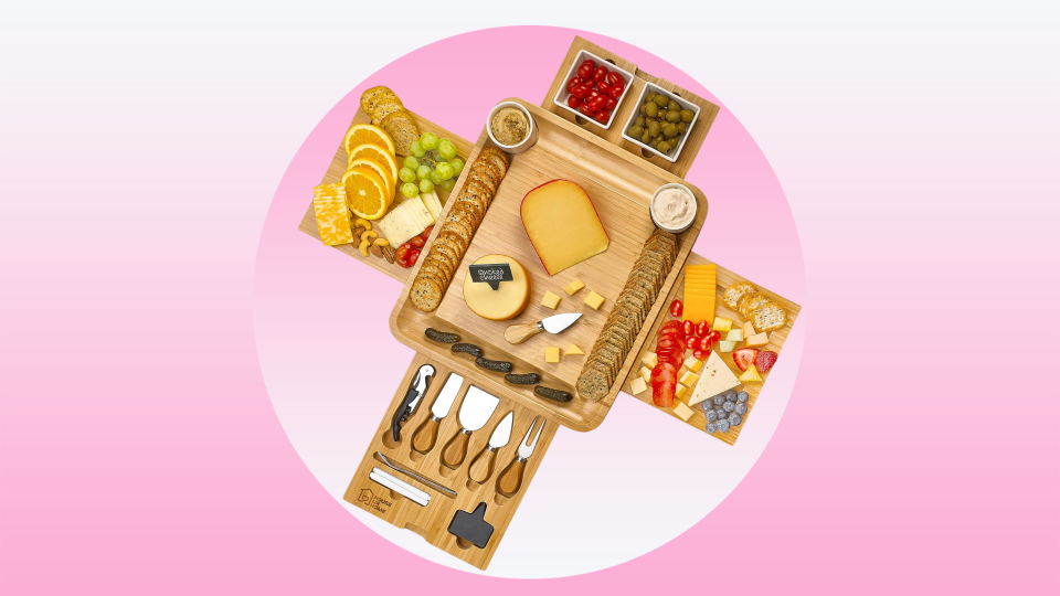 cheese board expanded with tools, cheese, fruit and crackers