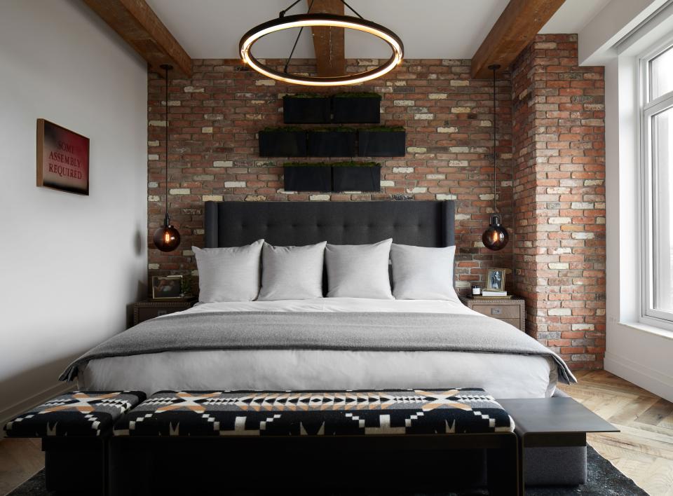 “One of the elements Kevin was dead set on bringing in to the bedroom was this reclaimed brick,” says Varnum. “He has something similar in a basement bar in his home in Cleveland.” The bed is custom by Wodarczyk Interiors Workroom, and the linens are custom as well, by Block Brothers. A Desiron bench was covered in Pendleton’s Spider Rock throw material. The overhead light is by Restoration Hardware. Love was also interested in bringing in some greenery, some nature into the bedroom, so Varnum introduced a low-maintenance living moss garden above his headboard.