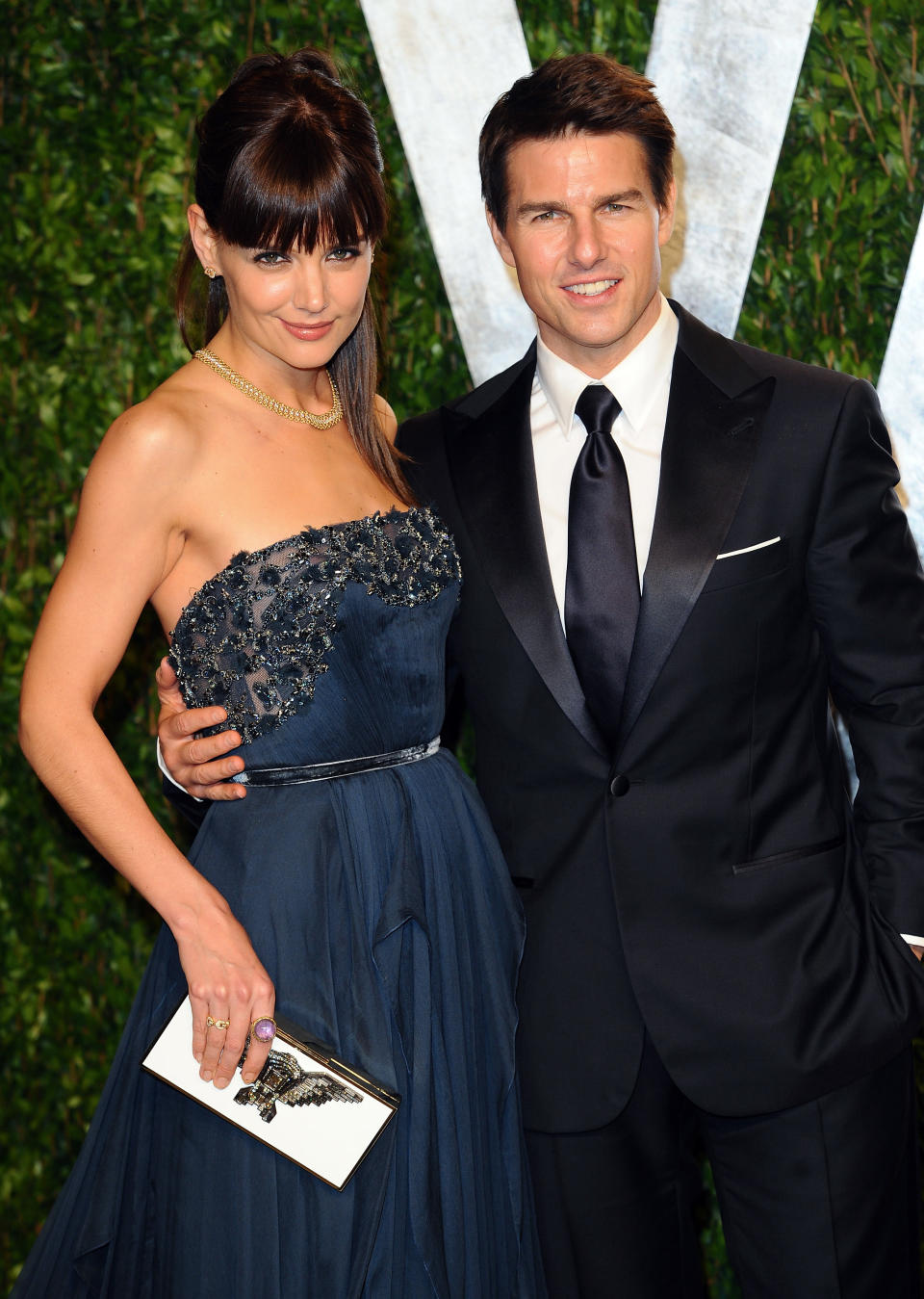 Katie Holmes and Tom Cruise with their arms around each other at an event