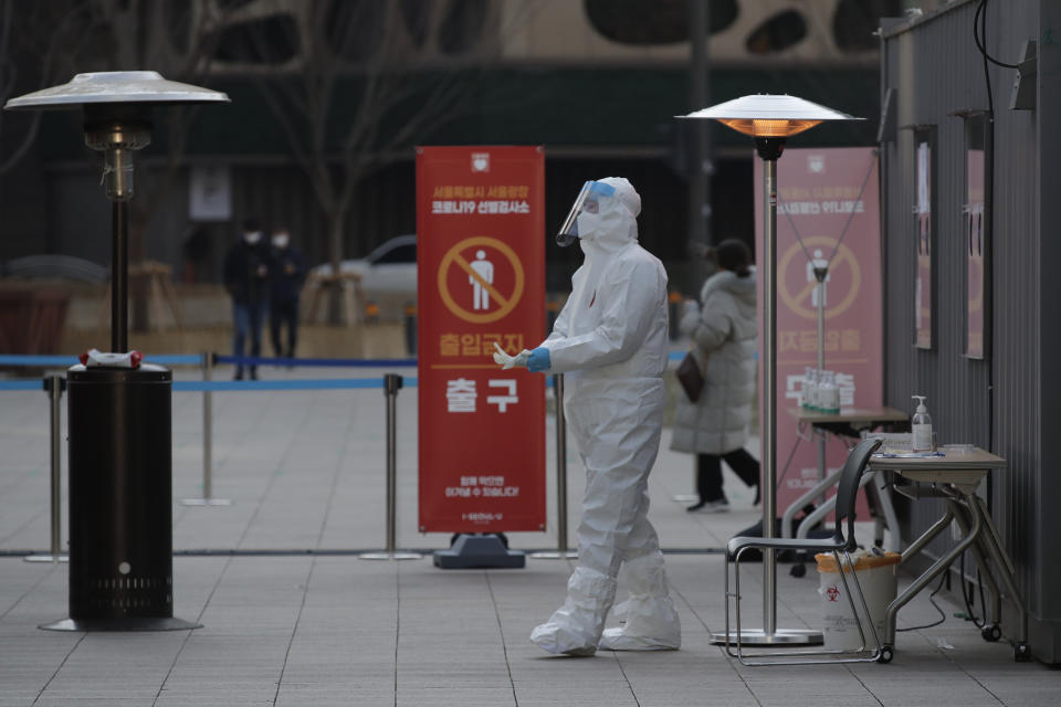 A medical worker wearing protective gears prepares to take sample in the sub-zero temperatures at coronavirus testing site in Seoul, South Korea, Monday, Dec. 21, 2020. (AP Photo/Lee Jin-man)