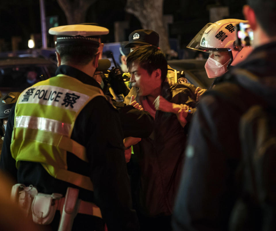 Oficiales de la policía detienen a un hombre en Shanghái, China, el domingo 27 de noviembre de 2022. (The New York Times)