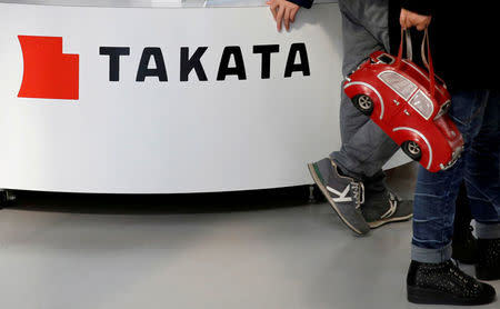 FILE PHOTO: Visitors walk past a logo of Takata Corp on its display at a showroom for vehicles in Tokyo, Japan February 5, 2016. REUTERS/Toru Hanai/File Photo