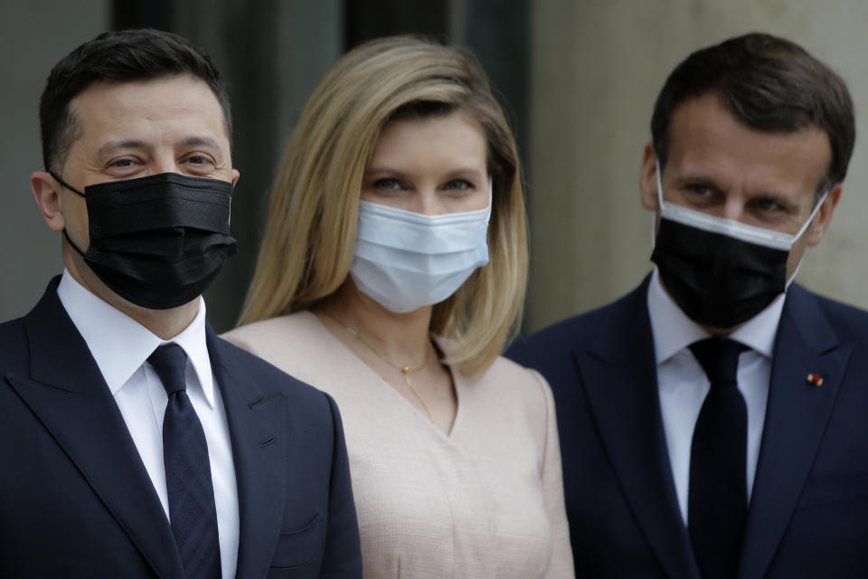 French President Emmanuel Macron, right, poses with Ukrainian President Volodymyr Zelenskyy, left, and Olena Zelenska before a working lunch at the Elysee palace in Paris, Friday, April 16, 2021. Ukrainian President Volodymyr Zelenskyy is holding talks with French President Emmanuel Macron and German Chancellor Angela Merkel amid growing tensions with Russia, which has deployed troops at the border with the country. (AP Photo/Lewis Joly)