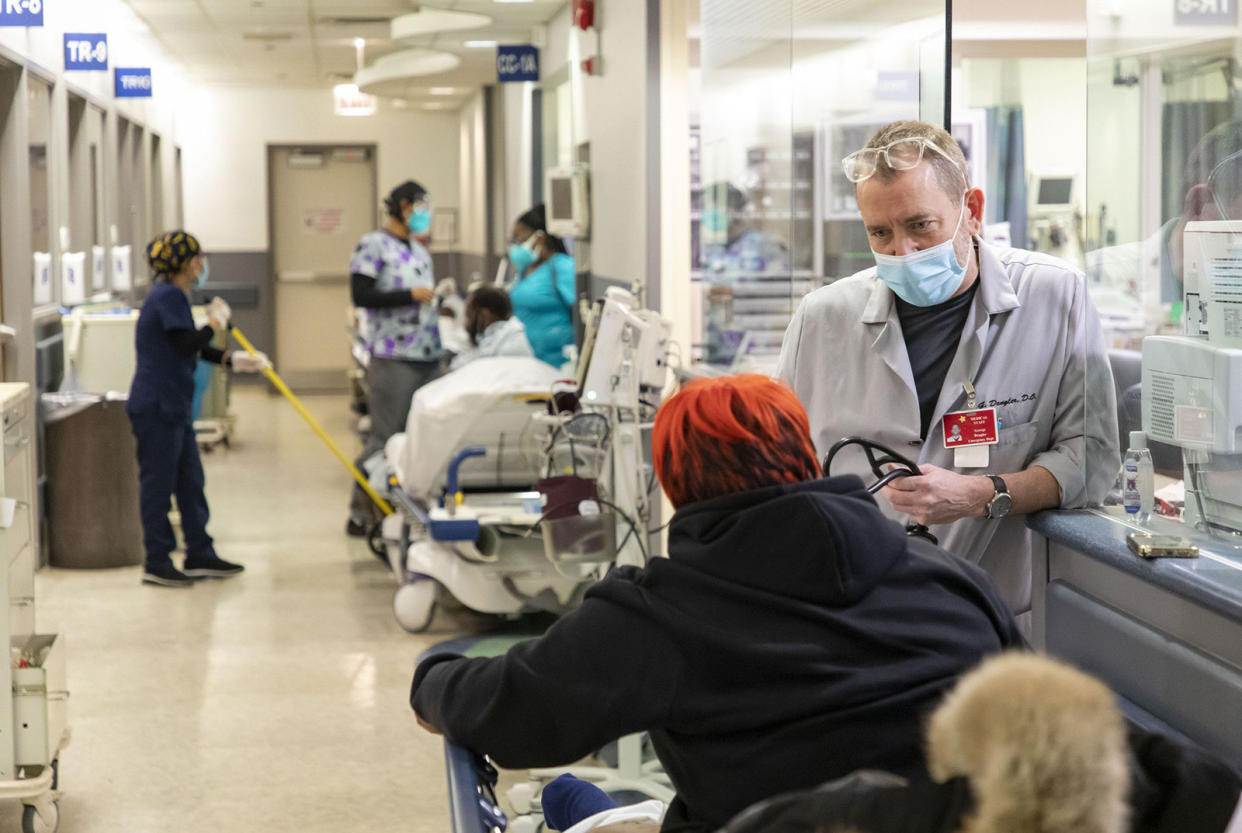 Dr. George Dengler talks to a patient in a hallway on Jan. 5, 2022, at St. Bernard Hospital in Englewood. (Brian Cassella/Chicago Tribune/Tribune News Service via Getty Images)