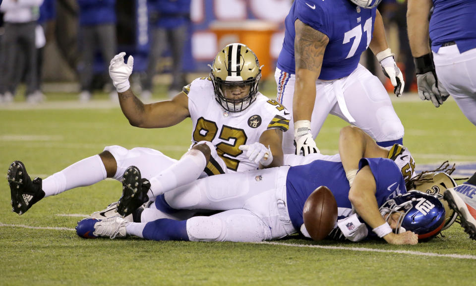 New York Giants quarterback Eli Manning, right, fumbles the ball as he is tackled during the second half of an NFL football game against the New Orleans Saints, Sunday, Sept. 30, 2018, in East Rutherford, N.J. The Saints defeated the Giants 33-18. (AP Photo/Julio Cortez)