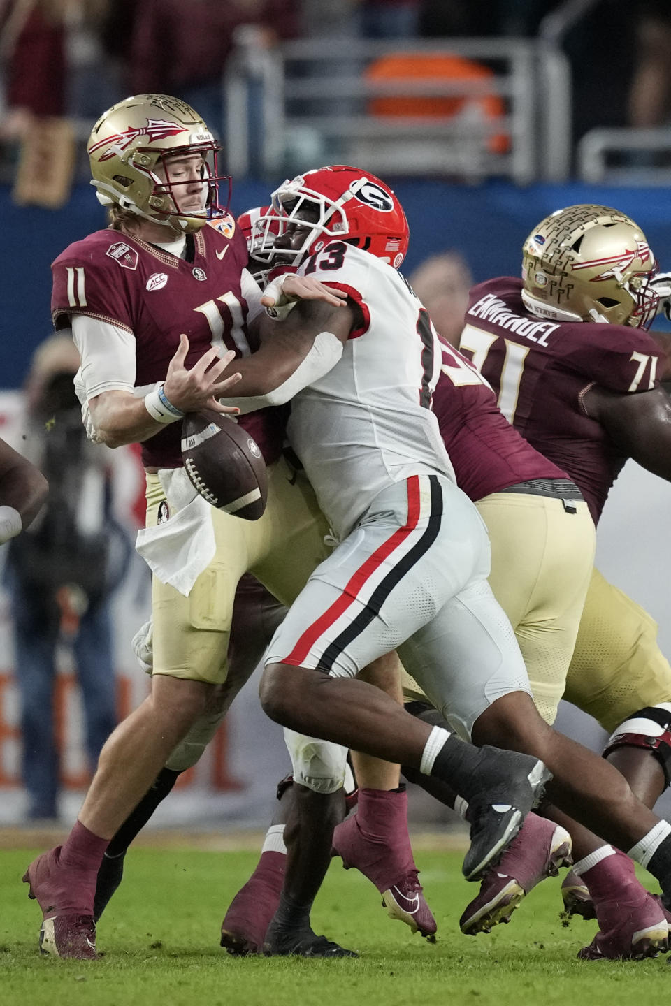 Florida State quarterback Brock Glenn (11) fumbles the ball as he is sacked by Georgia defensive lineman Mykel Williams (13) in the first half of the Orange Bowl NCAA college football game, Saturday, Dec. 30, 2023, in Miami Gardens, Fla. (AP Photo/Rebecca Blackwell)