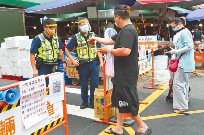 全台三級警戒，行政院推動簡訊實聯制，圖為29日台北市濱江市場外攤，警方嚴格執行進入都需實聯制。(陳俊吉攝)