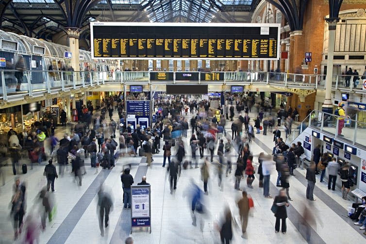 Liverpool Street Station in London as crowds of people rush through.