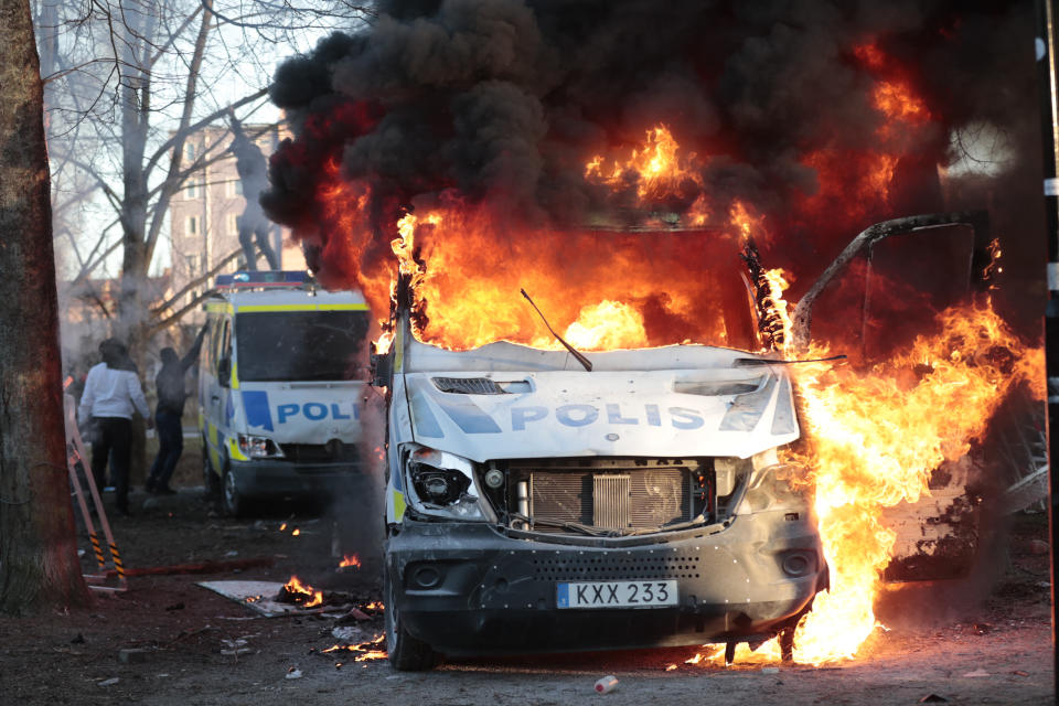 Protesters set fire to a police bus in the park Sveaparken in Orebro, Sweden, Friday, April 15, 2022. Police in Sweden say they are preparing for new violent clashes following riots that erupted between demonstrators and counter-protesters in the central city of Orebro on Friday ahead of an anti-Islam far-right group’s plan to burn a Quran there. (Kicki Nilsson/TT via AP)