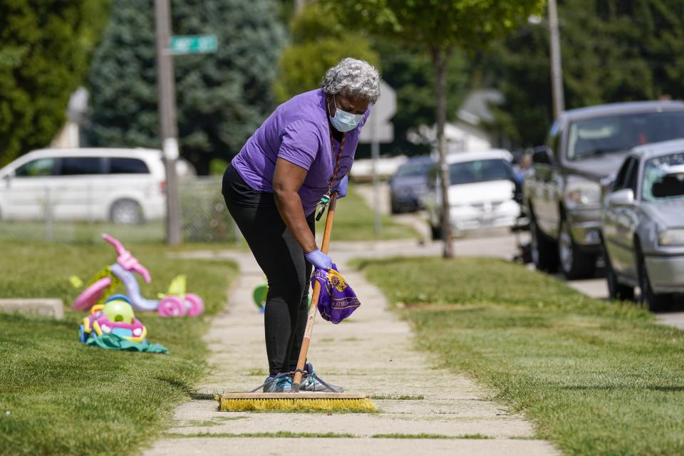 Church volunteer Patricia Antoine-Norton helps clean up the neighborhood where Jacob Blake was shot last Sunday on Saturday, Aug. 29, 2020, in Kenosha, Wis. Family members of Jacob Blake, a Black man who was paralyzed after a Kenosha police officer shot him in the back, are leading a march and rally Saturday to call for an end to police violence. (AP Photo/Morry Gash)