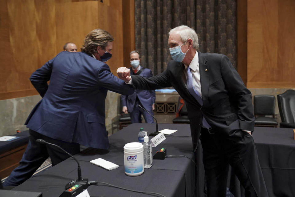 Christopher Krebs, former director of the Cybersecurity and Infrastructure Security Agency, elbow bumps Senate Homeland Security and Governmental Affairs Committee Chairman Ron Johnson, R-Wis., after a hearing to discuss election security and the 2020 election process on Wednesday, Dec. 16, 2020, on Capitol Hill in Washington. (Greg Nash/Pool via AP)