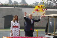 U.S. President Donald Trump offers floral respects, with first lady Melania Trump standing beside him, at Raj Ghat, the memorial for Mahatma Gandhi, in New Delhi, India, Tuesday, Feb. 25, 2020. (AP Photo/Alex Brandon)