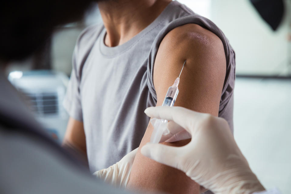 Close-up of hands injecting  male patients arm .Doctor giving a patient injection.