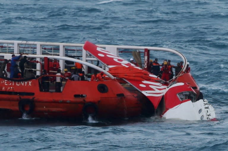 Indonesian search and rescue personnel pull wreckage of AirAsia flight QZ8501 onto the Crest Onyx ship at sea on January 10, 2015