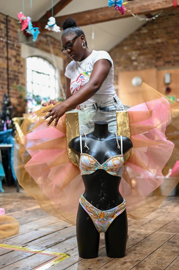 Rishelle, a designer for Funatik's Mas Band, adjusts a costume for her Carnival section, 