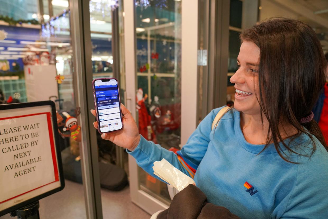 Lindsey Kirkland, 28, shows off canceled Southwest flights on her phone after her own flight to Reno, Nevada, was canceled on Tuesday, Dec. 27, 2022, at Denver International Airport.