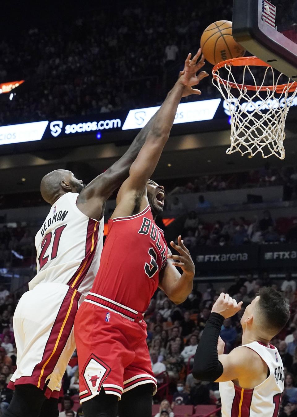 Miami Heat center Dewayne Dedmon (21) blocks a shot to the basket by Chicago Bulls forward Tristan Thompson (3) during the first half of an NBA basketball game Monday, Feb. 28, 2022, in Miami. (AP Photo/Marta Lavandier)