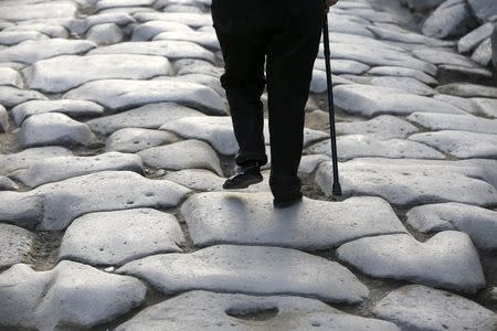 A tourist walks on an ancient Roman cobbled street at the UNESCO World Heritage site of Pompeii, October 13, 2015. REUTERS/Alessandro Bianchi