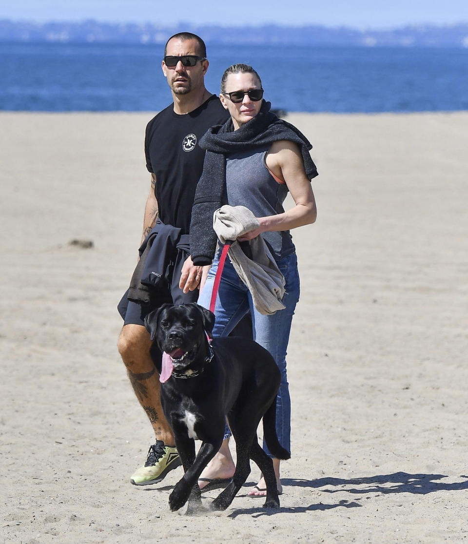 <p>Robin Wright and her husband Clement Giraudet take a walk on the beach in Santa Monica, California, with their pup on Tuesday.</p>