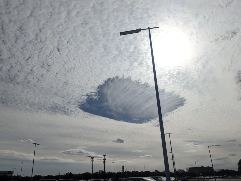 Street lamp post with unique cloud formation behind it in a daylight sky