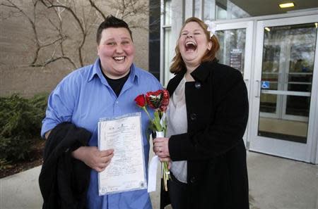 Newly married Sarah Brown (L) and Dolly Vanfossan hold their marriage license outside after being married at the Oakland County Courthouse, after a Michigan federal judge ruled a ban on same-sex marriage violates the U.S. Constitution and must be overturned in Pontiac, Michigan March 22, 2014. REUTERS/Rebecca Cook