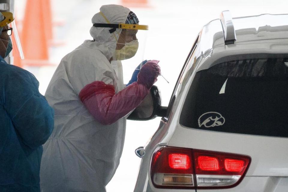 Iowa Department of Public Health workers administer coronavirus tests in a parking lot in Waterloo.