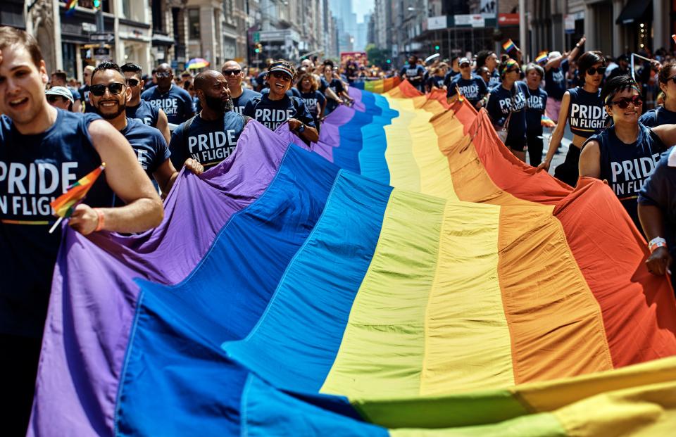 FILE- In this June 24, 2018 file photo, revelers carry a LGBTQ flag along Fifth Avenue during the New York City Pride Parade in New York. New York City will host two parades on Sunday, June 30, 2019, in celebration of the 50th anniversary of the Stonewall uprising. The smaller of the two, Queer Liberation March, starts at 9:30 a.m. and the larger Pride march steps off at noon. (AP Photo/Andres Kudacki, File)