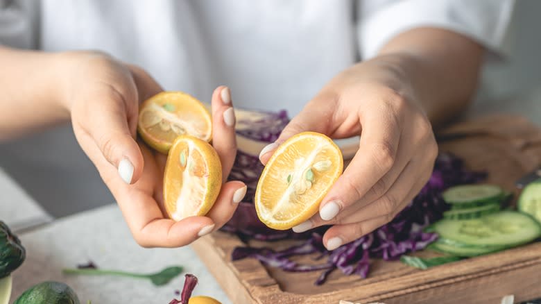 Hands holding halved limequats