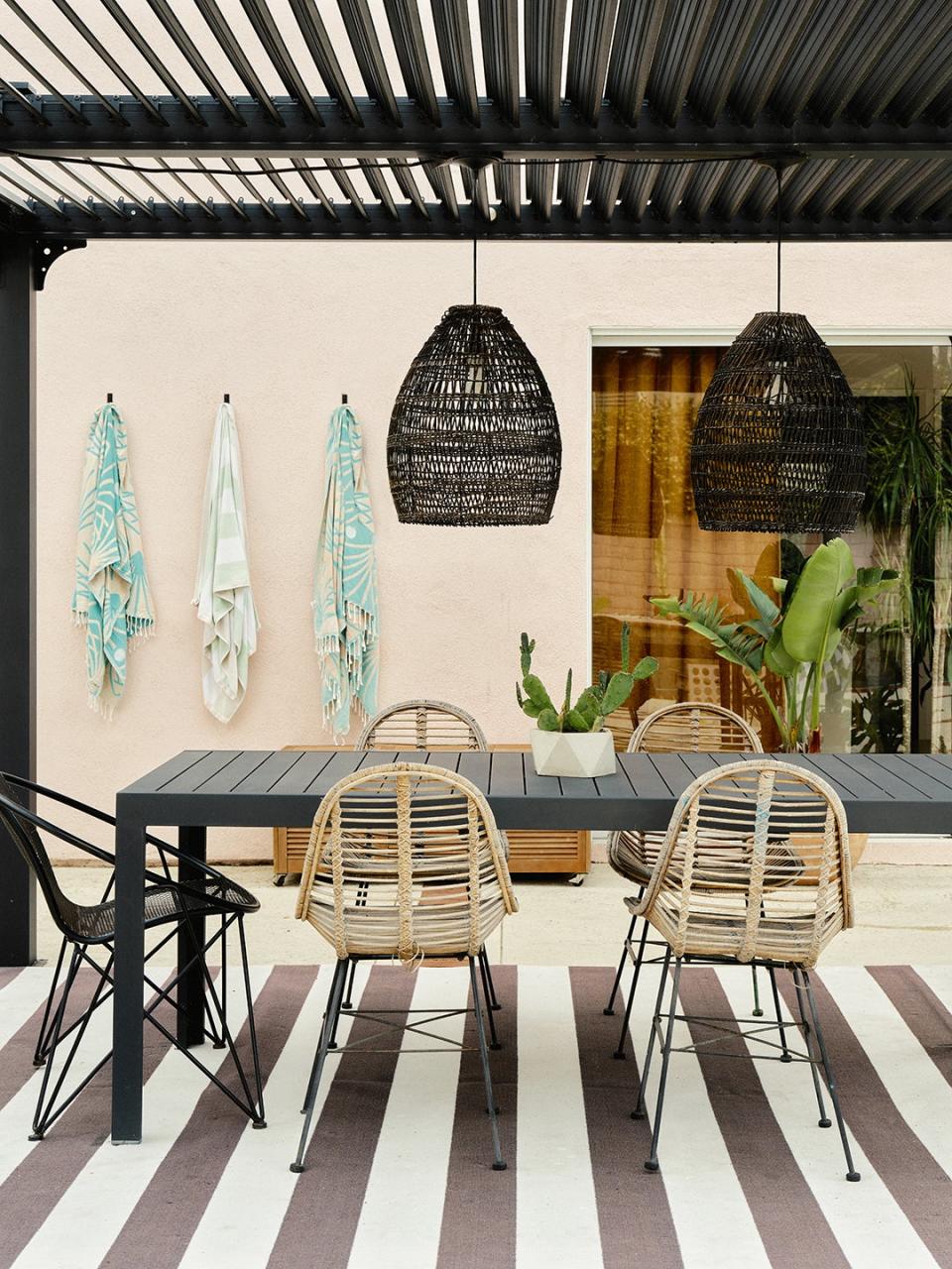 Alfresco Outdoor Dining Table, <u>Crate & Barrel</u> Chairs; Woven Bamboo Pendant Shade in Black, <u>World Market</u>; Fairest Pink Paint (on exterior), <u>Benjamin Moore</u>.