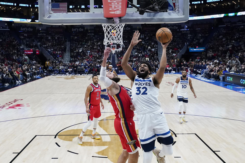 Minnesota Timberwolves center Karl-Anthony Towns (32) goes to the basket against New Orleans Pelicans center Jonas Valanciunas in the first half of an NBA basketball game in New Orleans, Monday, Dec. 11, 2023. (AP Photo/Gerald Herbert)