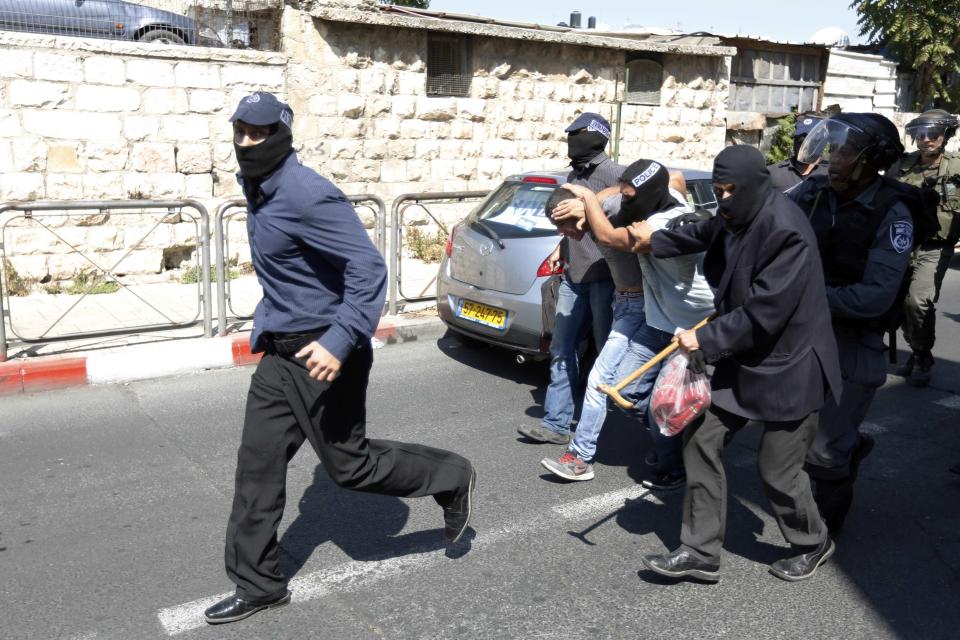 Undercover Israeli policemen detain a Palestinian during clashes following Friday prayers near Jerusalem's Old City