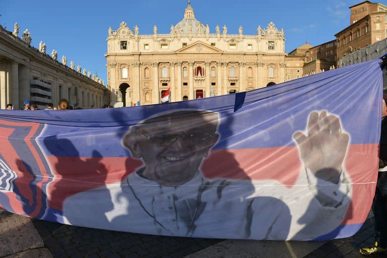 Faithful hold a banner with picture of Pope Francis in St Peter's Square on March 19, 2013 at the Vatican. Hundreds of thousands of people are expected to turn out in for the inauguration of Latin America's first pontiff