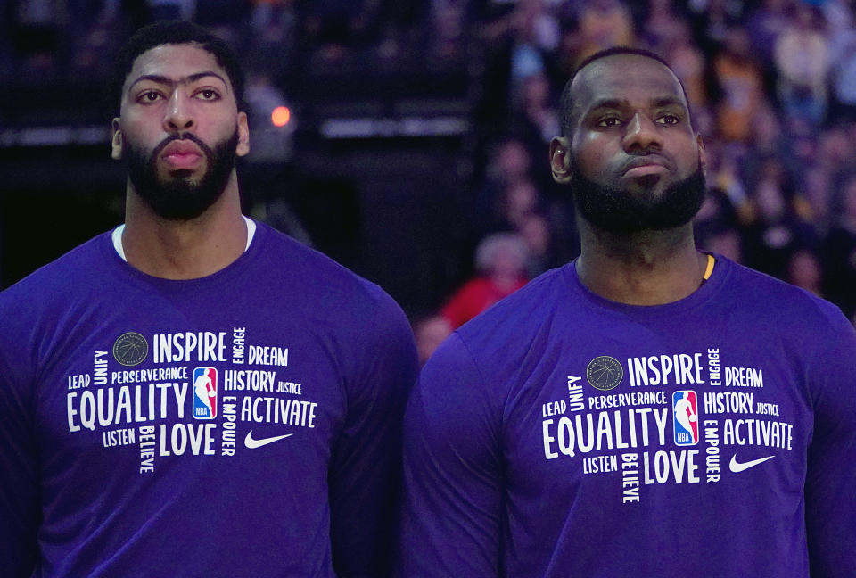 LeBron James #23 (R) and Anthony Davis #3 of the Los Angeles Lakers (L) stands for the National Anthem prior to the start of an NBA basketball game against the Sacramento Kings.