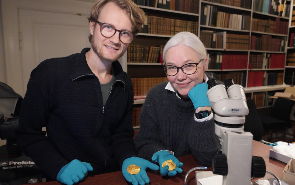 Experts Krister Vasshus, left, and Lisbeth Imer hold golden bracteates unearthed in Vindelev, Denmark in late 2020. Imer holds golden bracteate featuring ‘He is Odin’s man’ inscription. Scandinavian scientists said Wednesday that they have identified the oldest-known inscription referencing to the Norse god Odin, on part of a gold disc unearthed in western Denmark in 2020. (John Fhær Engedal Nissen, The National Museum of Denmark via AP)