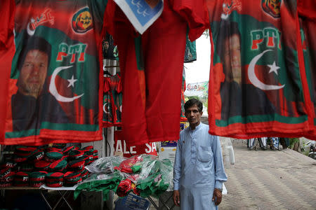 A man stands next to the t-shirts with images of Imran Khan, leader of the Pakistan Tehreek-e-Insaf (PTI) at a market, a day after general election in Islamabad, Pakistan, July 26, 2018. REUTERS/Athit Perawongmetha