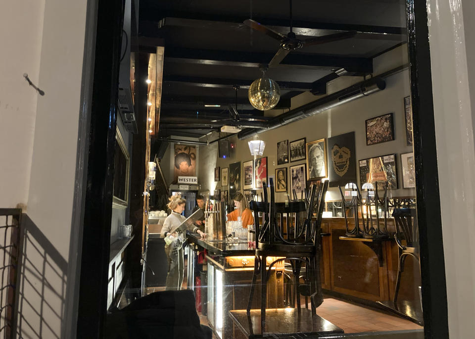 Staff at Café De Oude Wester close up just after 5pm in Amsterdam, Netherlands, Sunday, Nov. 28, 2021, as a tougher lockdown came into effect starting 5 pm, moving closing time forward three hours amid swiftly rising infections and ICU admissions.(AP Photo/Mike Corder)