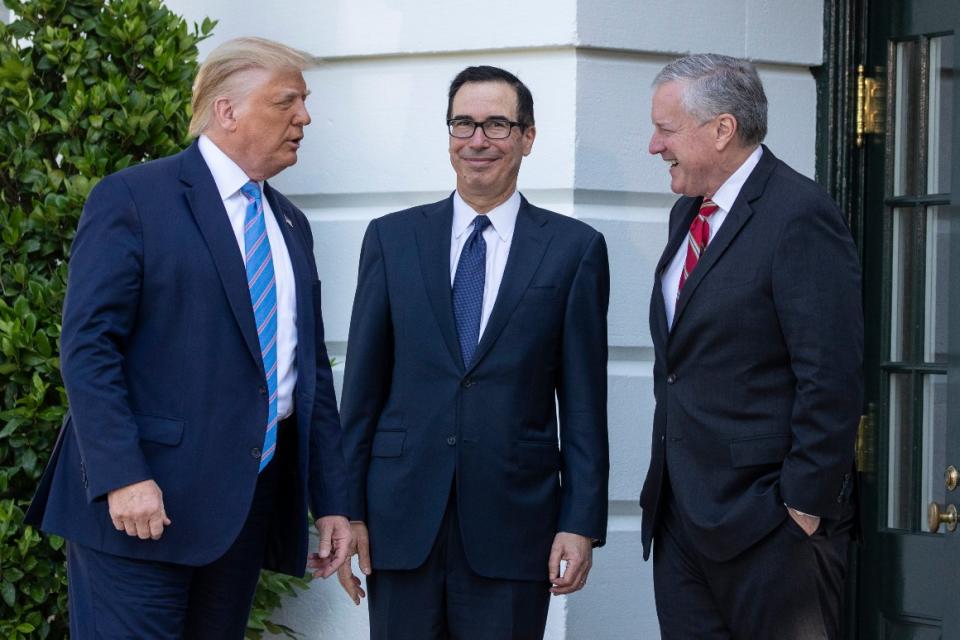 President Donald Trump, Treasury Secretary Steven Mnuchin, White House Chief of Staff Mark Meadows talk before Trump speaks with reporters on the South Lawn of the White House, Wednesday, July 29, 2020, in Washington.