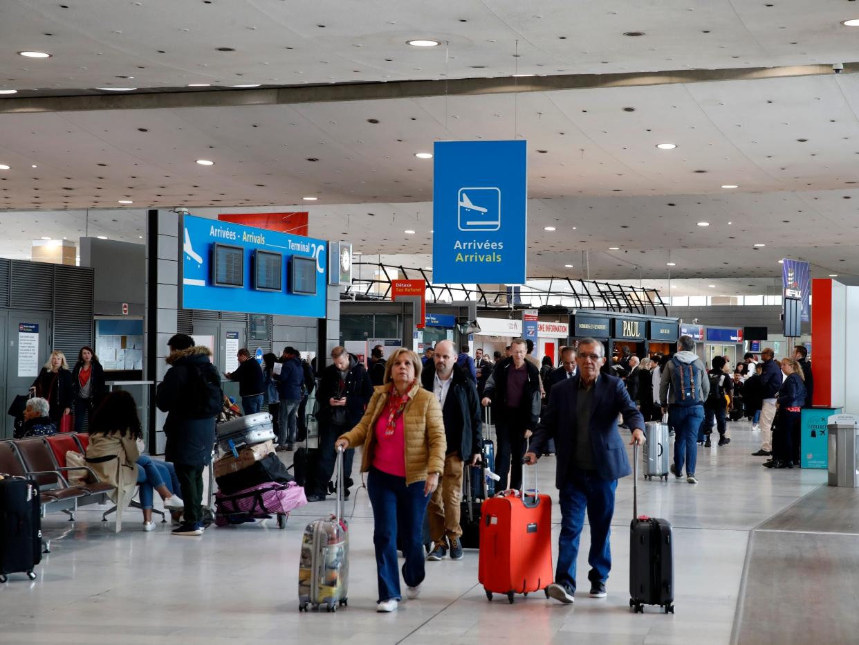 Passengers walk in the arrivals hall of Paris Charles de Gaulle airport