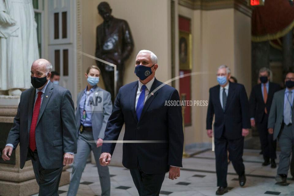 After violent protesters stormed the U.S. Capitol, Vice President Mike Pence leads senators to the House chamber to continue the joint session of the House and Senate and count the Electoral College votes on Jan. 6. (AP Photo/J. Scott Applewhite)