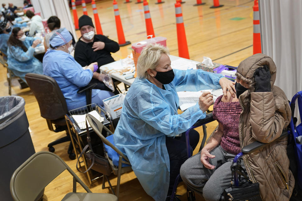 Miriam Palomino, right, received the COVID-19 vaccine in Paterson, N.J., Thursday, Jan. 21, 2021. The first people arrived around 2:30 a.m. for the chance to be vaccinated at one of the few sites that does not require an appointment. (AP Photo/Seth Wenig)