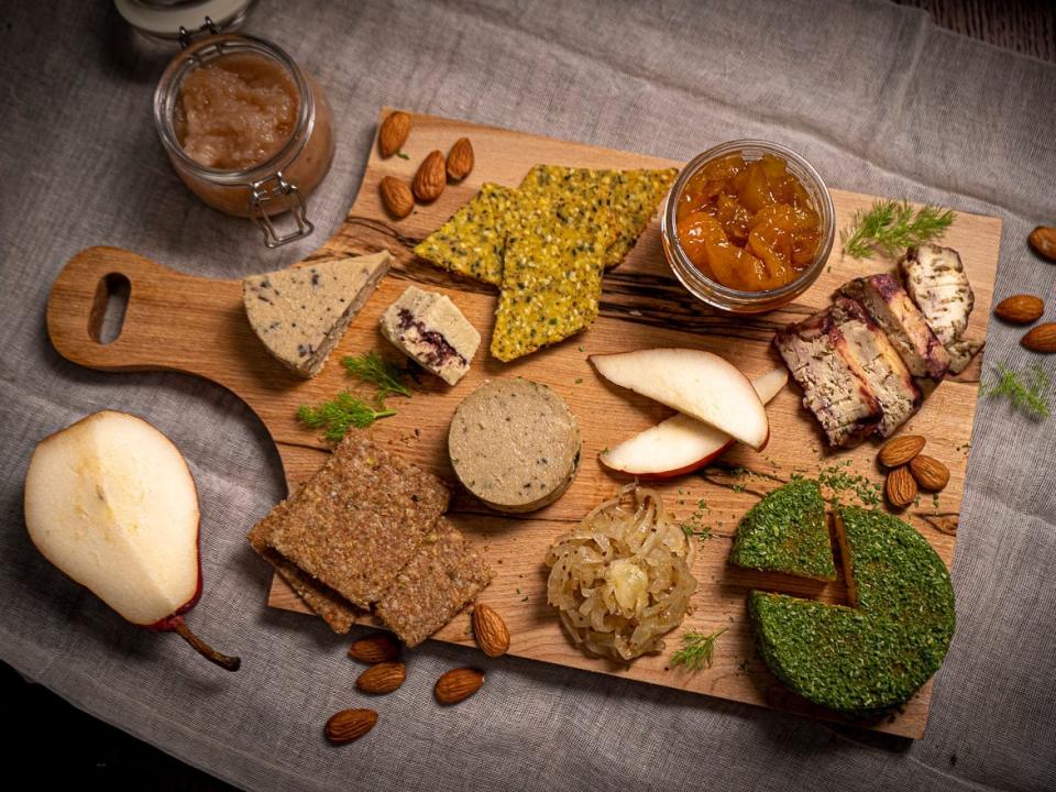 A board with homemade vegan cheeses, crackers, and chutneys.