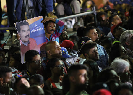 Supporters watch as Venezuela's President Nicolas Maduro speaks during a gathering after the results of the election were released, outside of the Miraflores Palace in Caracas, Venezuela, May 20, 2018. REUTERS/Carlos Garcia Rawlins