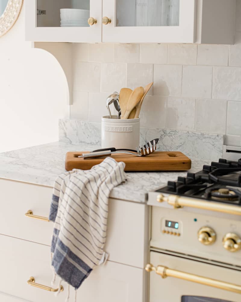 Detail of marble countertops and tile backsplash in remodeled white kitchen