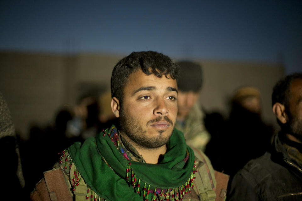 In this Tuesday, March 19, 2019, photo, a U.S.-backed Syrian Democratic Forces (SDF) soldier stands in formation before being dismissed after completing his unit's operation to oust Islamic State militants from Baghouz, Syria. (AP Photo/Maya Alleruzzo)