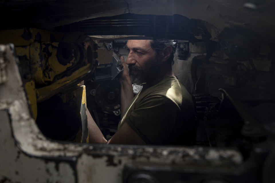 An Ukrainian serviceman repairs his tank after fighting against Russian forces in Donetsk region, eastern Ukraine, Wednesday, April 27, 2022. (AP Photo/Evgeniy Maloletka)